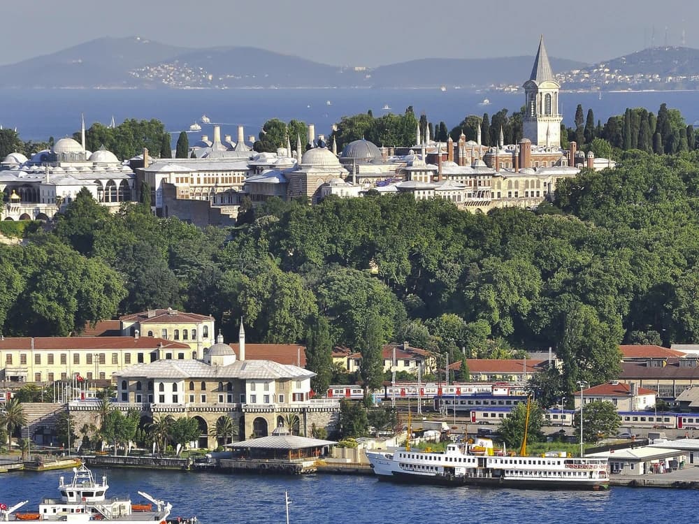 Topkapi Palace's Imperial Gate with the domes of the Treasury visible and the Bosphorus in the background