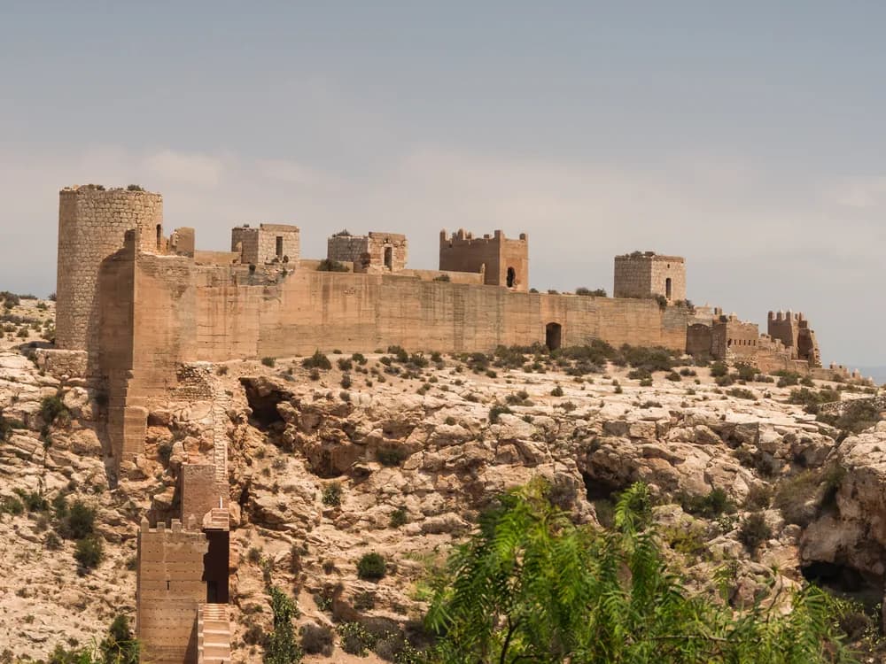 The Alcazaba of Almería's Umayyad fortress walls and reconstructed gardens overlooking the city and the Mediterranean coast