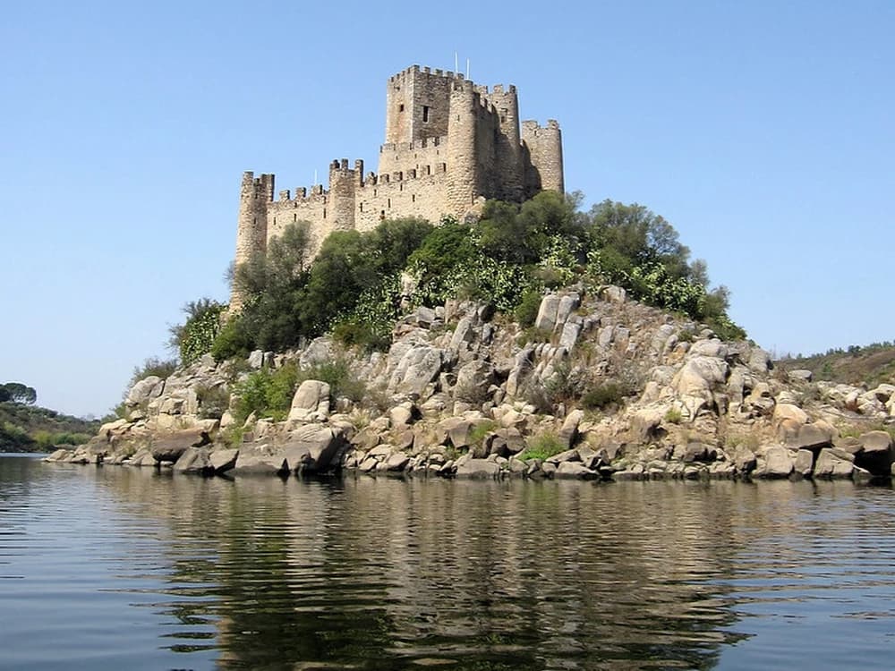 Almourol Castle rising from its island in the Tagus River, Portugal, with its 10 Templar towers reflected in the water