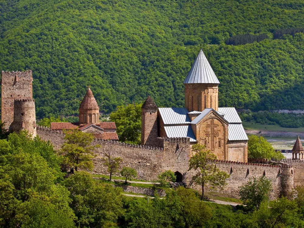 Ananuri Fortress medieval towers and churches reflected in the turquoise Zhinvali Reservoir in the Caucasus mountains of Georgia