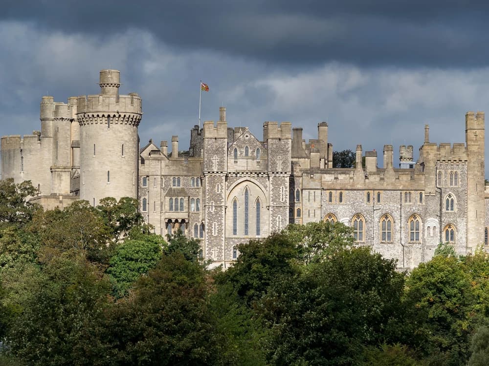 Arundel Castle's Gothic Revival towers and Norman motte rising dramatically above the River Arun valley in West Sussex on a clear autumn day
