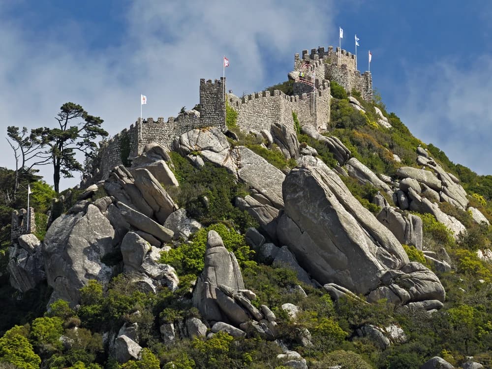 Castle of the Moors ramparts on the Sintra ridge with Pena Palace visible behind and the Atlantic in the distance