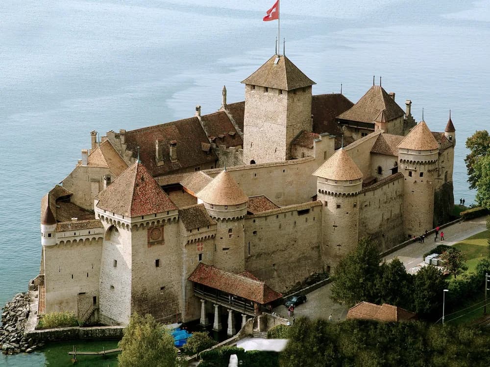 Château de Chillon rising from Lake Geneva with the Swiss Alps reflected in the still water