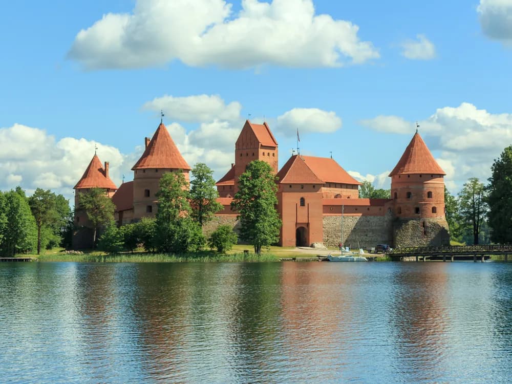 Trakai Island Castle red Gothic towers reflected in Lake Galvė at sunset, Lithuania
