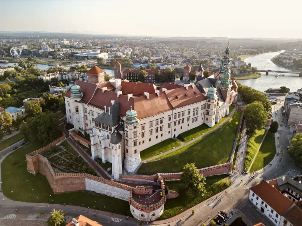 Wawel Royal Castle above the Vistula River at dawn, with the cathedral dome and fortifications visible