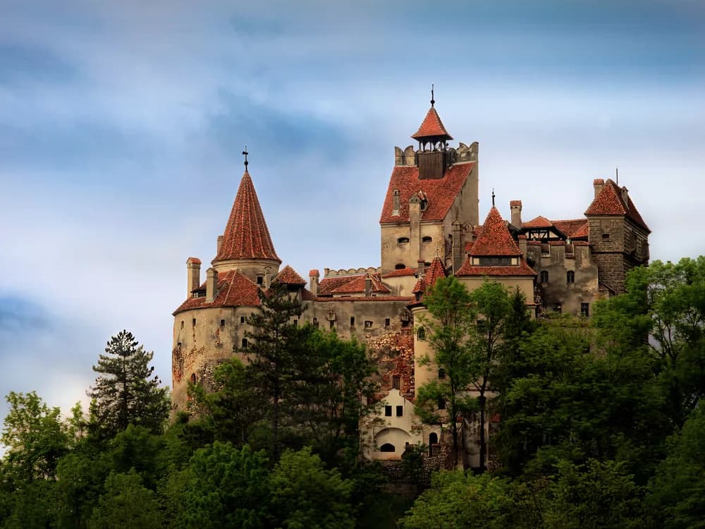 Bran Castle rising above the Transylvanian forest at dusk