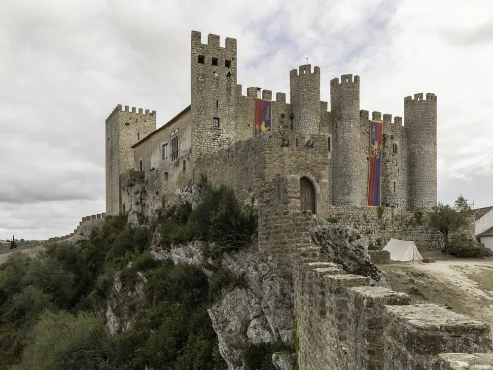 The white walls and castle of Óbidos village rising above the Portuguese countryside
