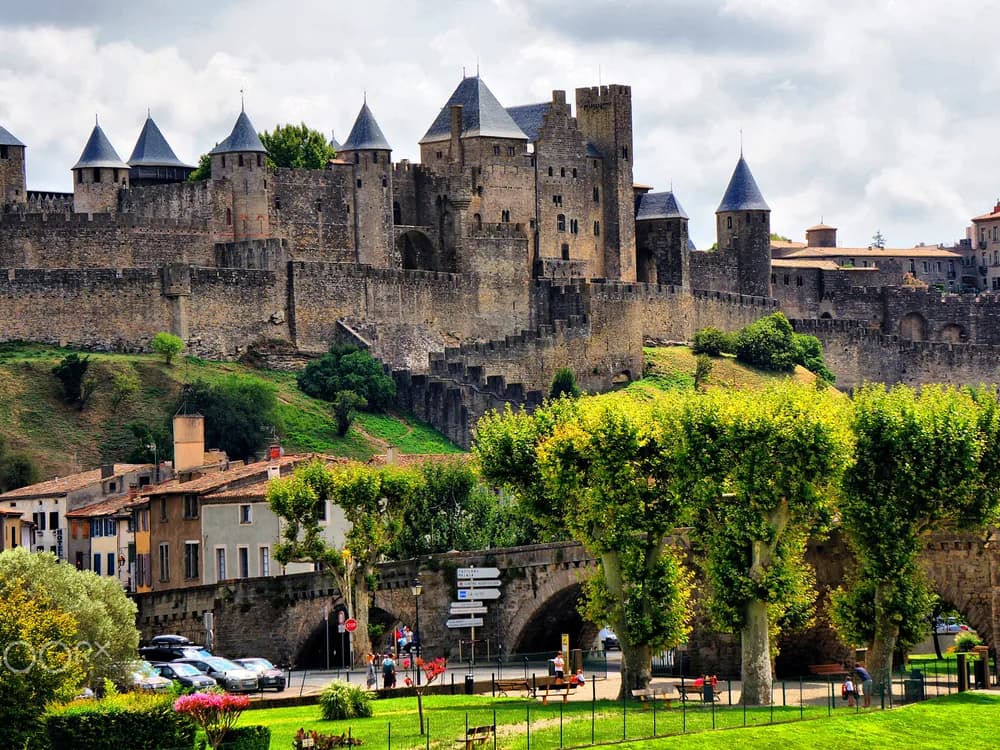 Carcassonne's medieval ramparts and towers rising above the Aude valley at dusk