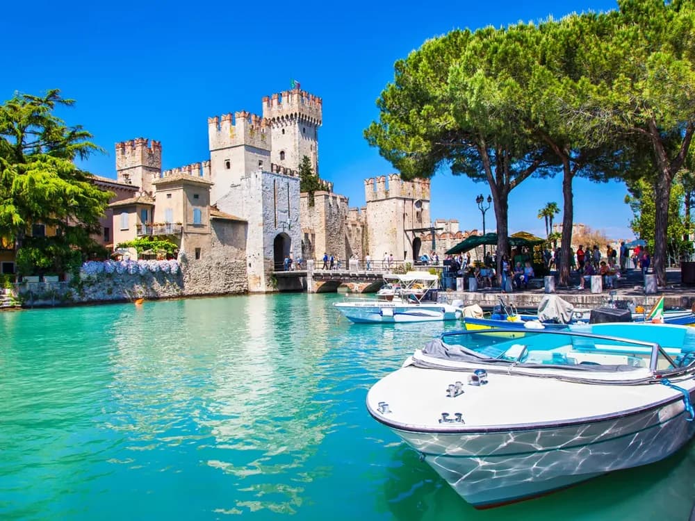 Lake Garda panorama with medieval tower and crystal-clear water