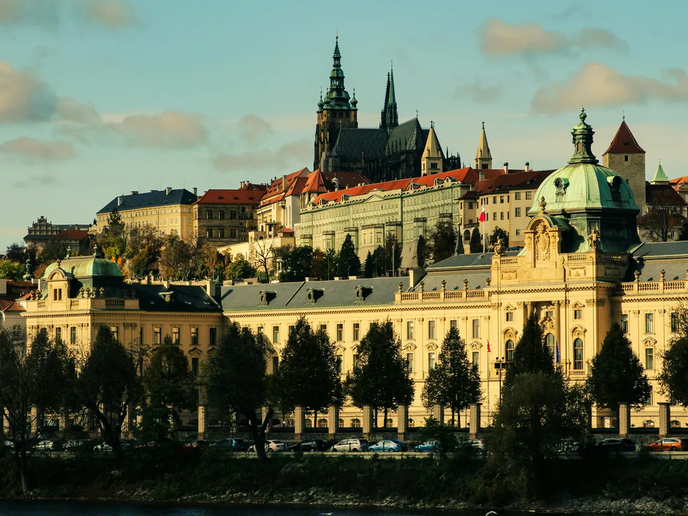 Prague Castle and St. Vitus Cathedral rising above the Vltava river and red rooftops of Malá Strana