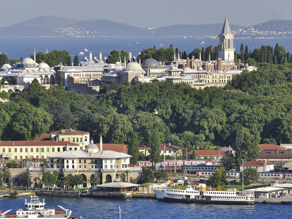 Topkapi Palace's Imperial Gate with the domes of the Treasury visible and the Bosphorus in the background